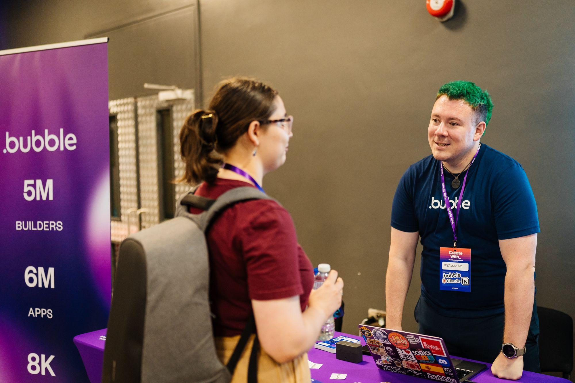 An attendee talking with the Bubble team at the Bubble stand