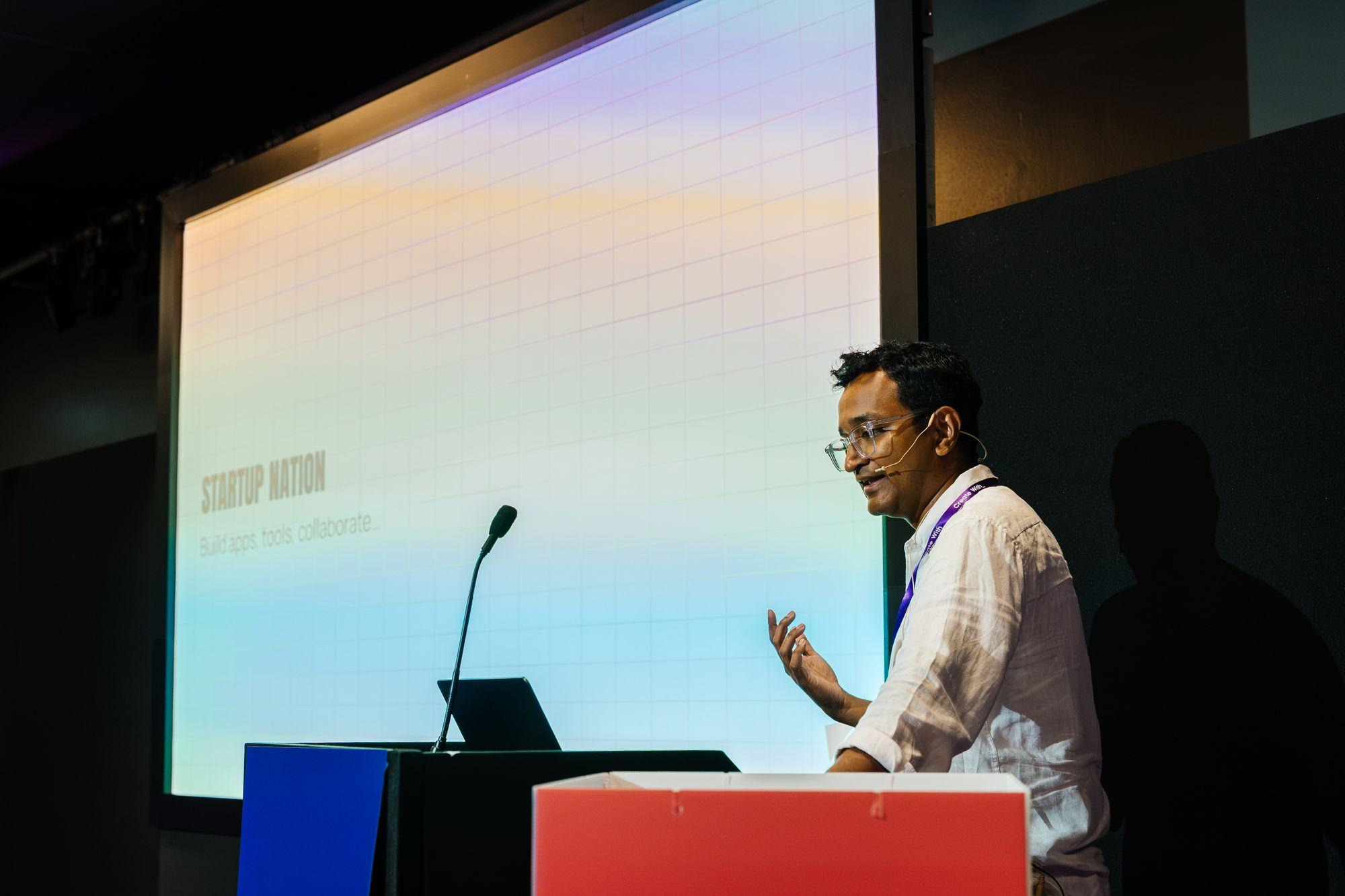 A workshop speaker at the lectern with slides projected