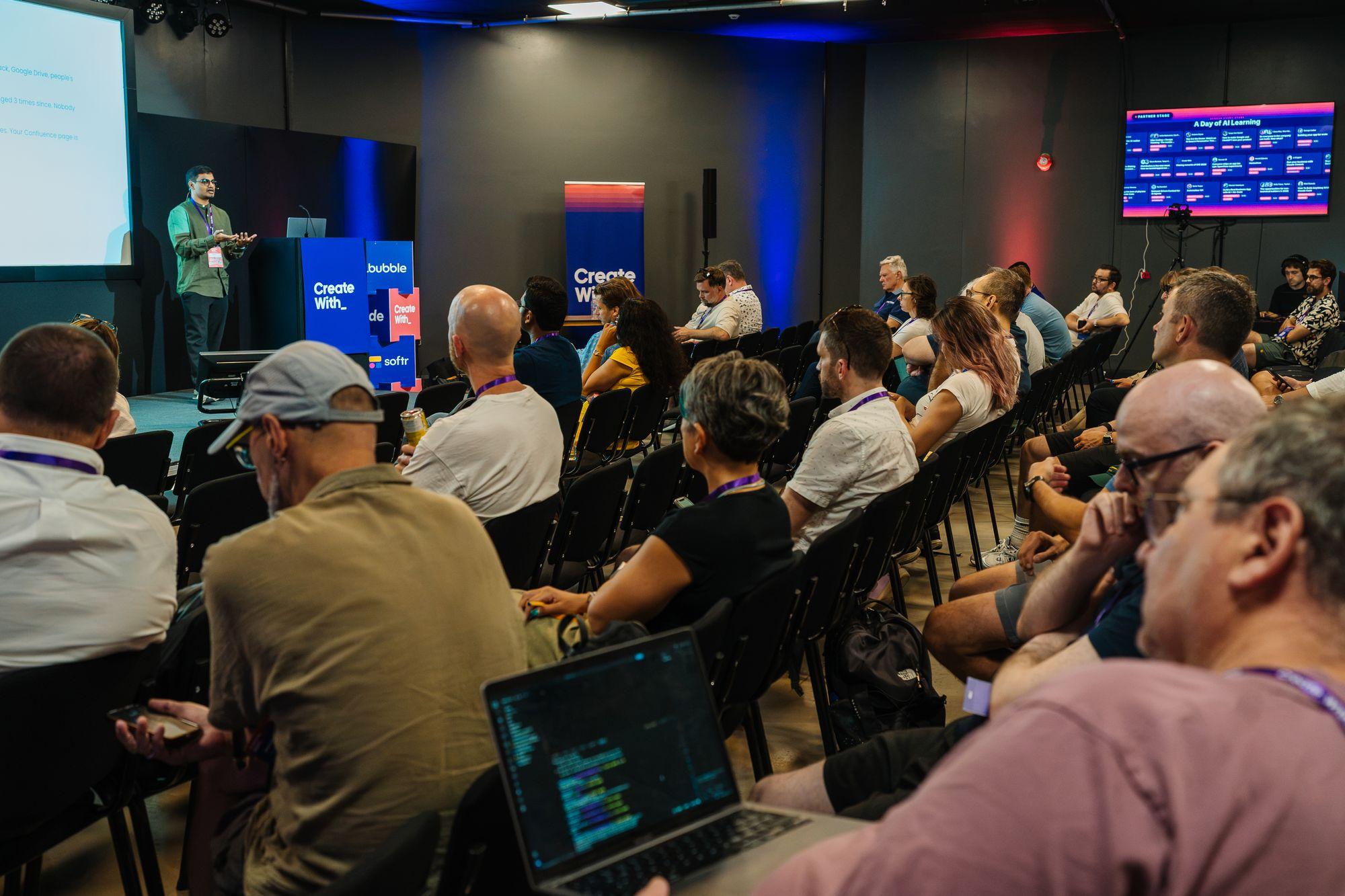 A workshop room from the back, attendees on laptops