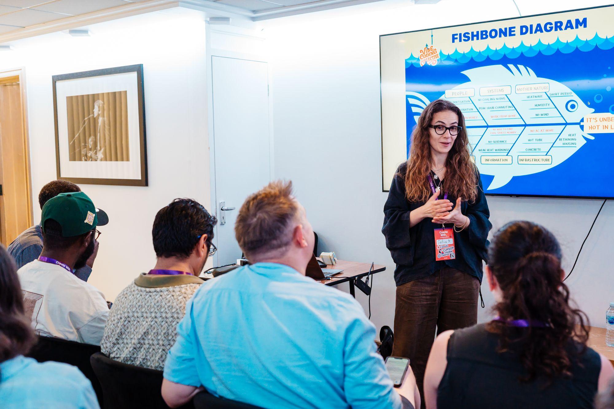A workshop presenter beside a fishbone diagram slide