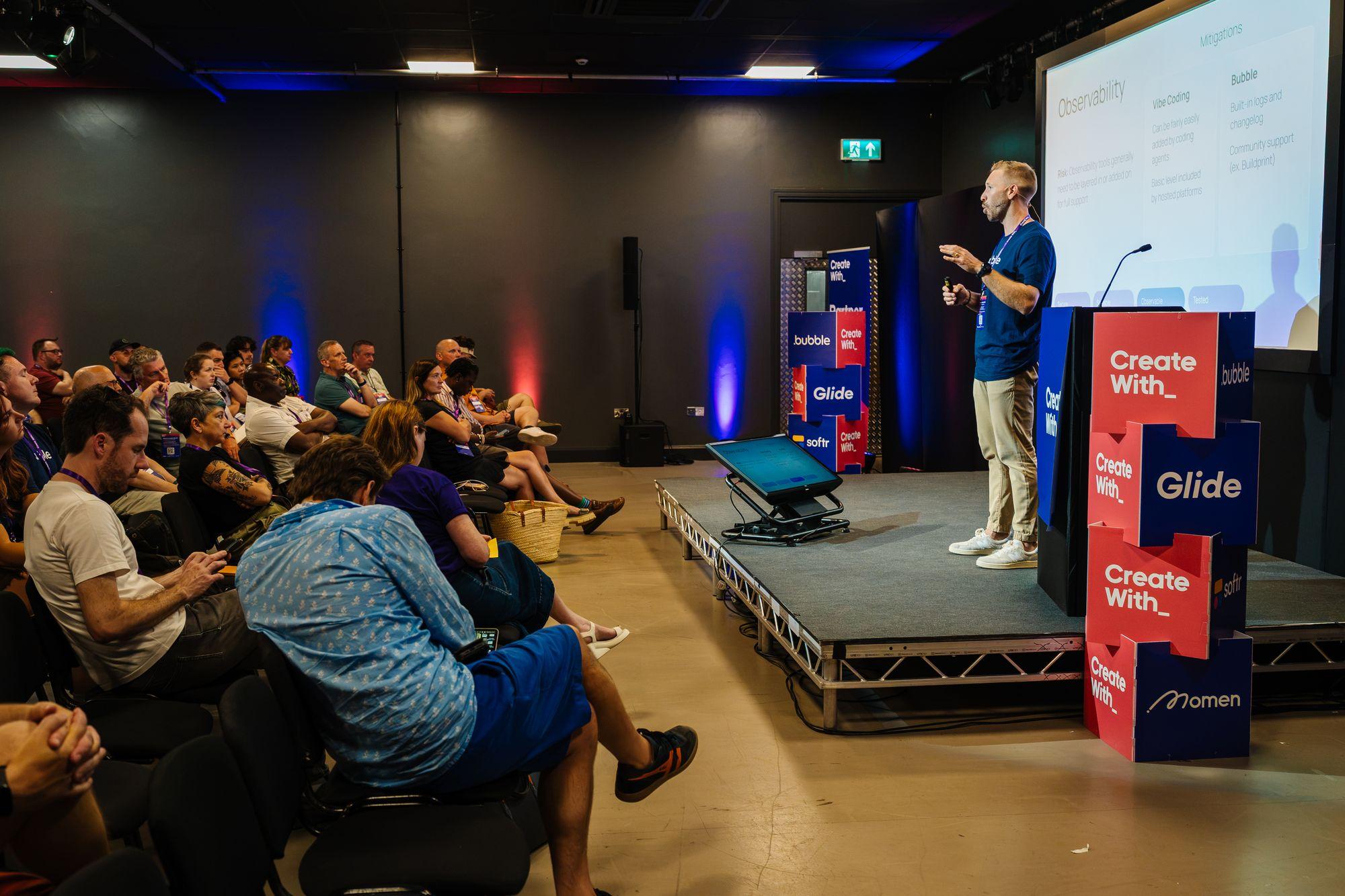 A speaker on the main stage with the audience in the foreground