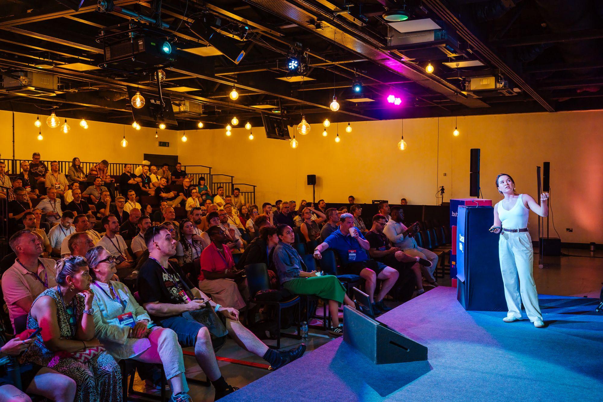 A speaker on stage in front of the seated audience