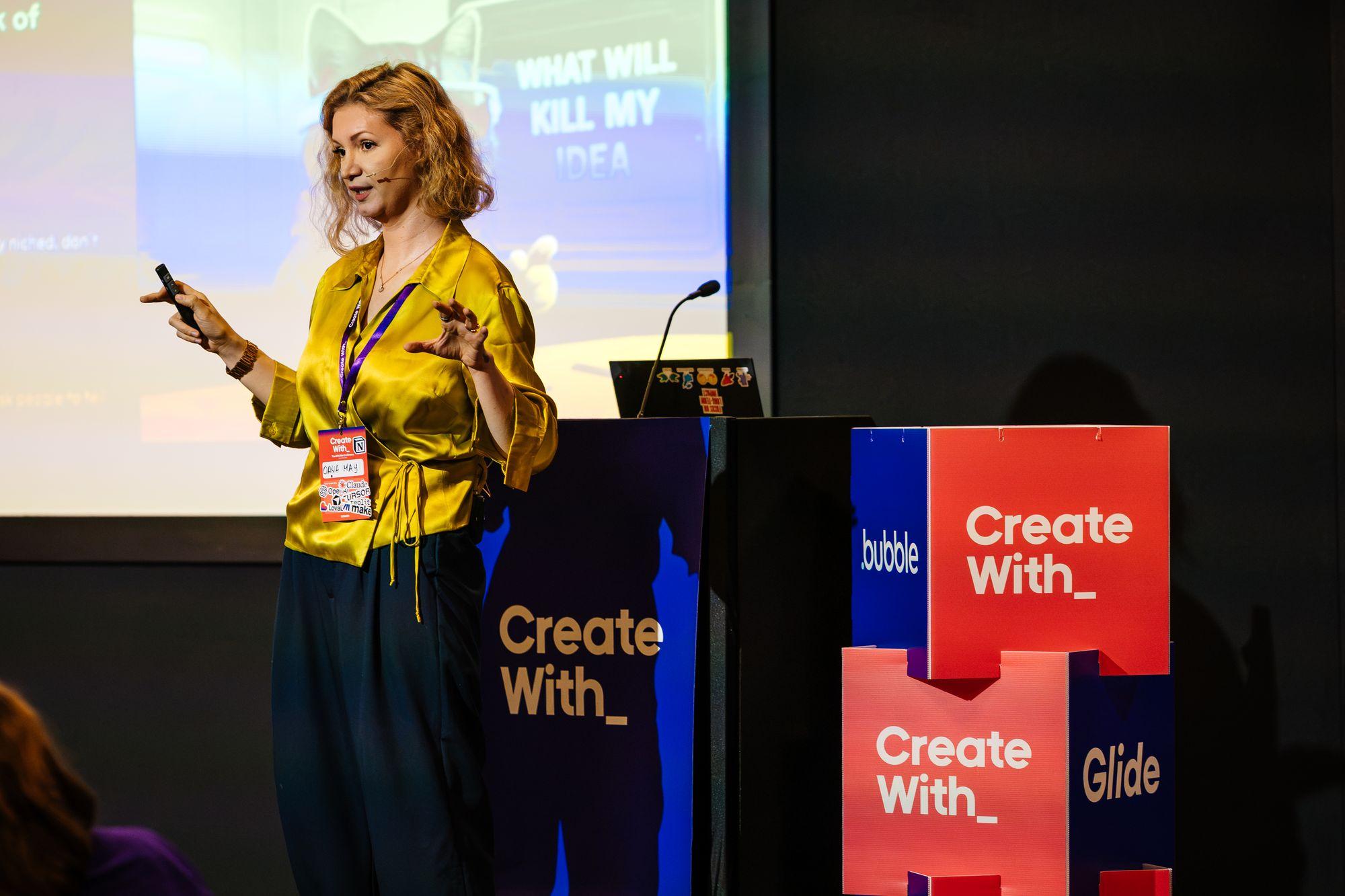 A speaker in a gold blouse at the lectern