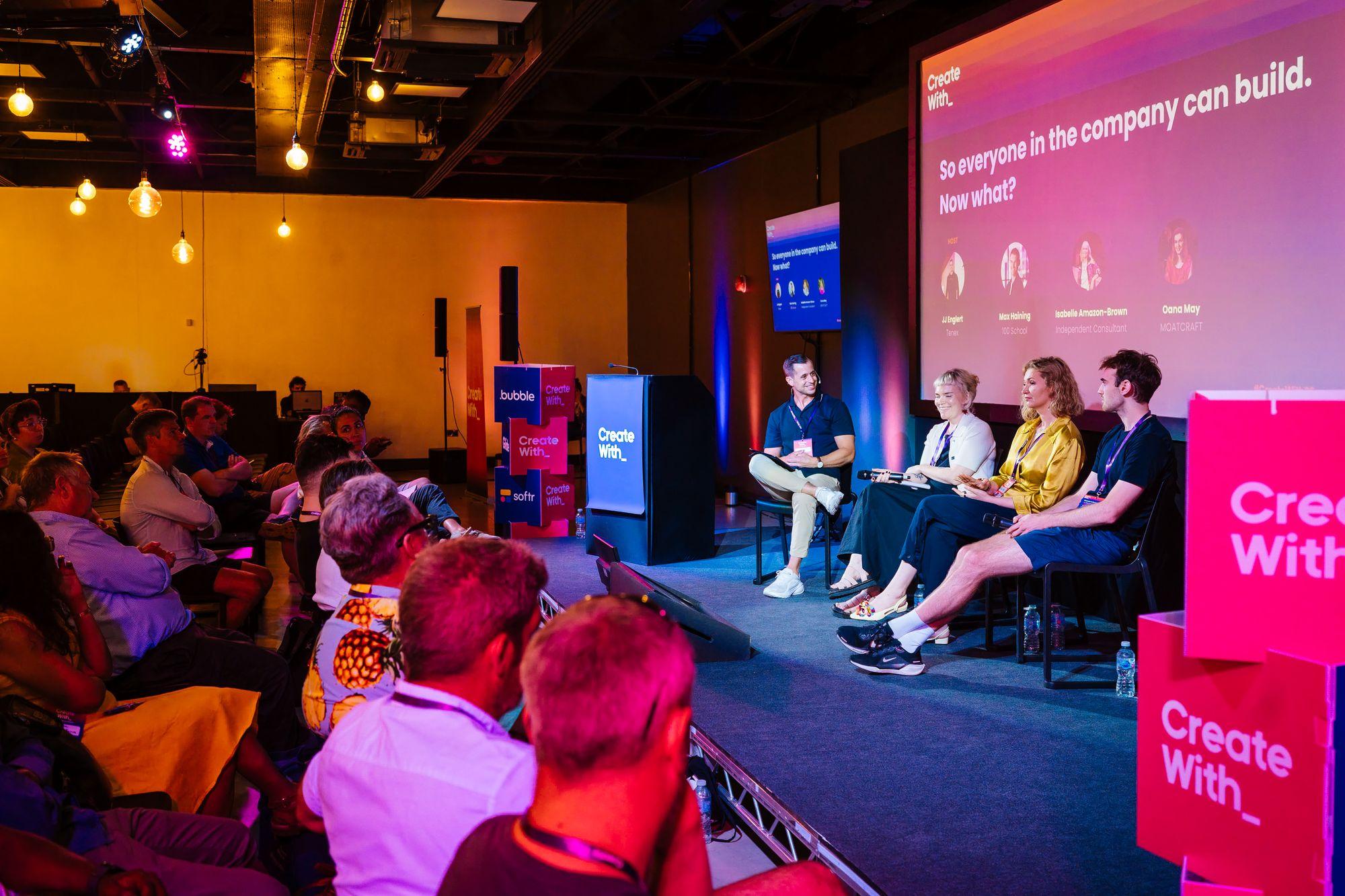 A panel on the pink-lit main stage