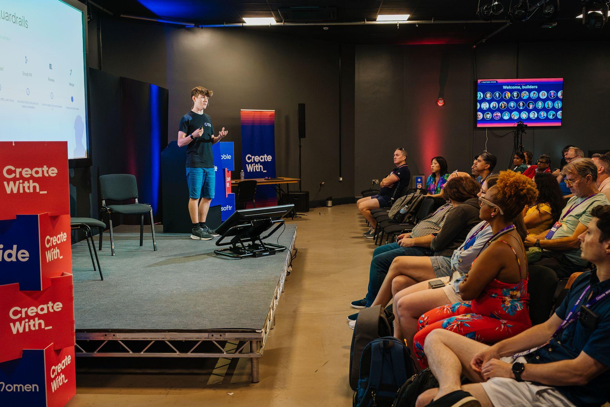 A speaker on a smaller stage with the audience in the foreground